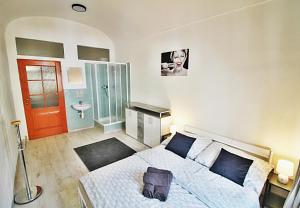 a bedroom with a bed and a bathroom with a sink at Lacná izba v centre in Banská Bystrica