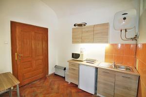 a small kitchen with a sink and a wooden door at Lacná izba v centre in Banská Bystrica