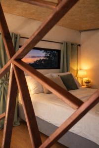 a bed in a room with a large window at Ti kaz du piton in Cilaos