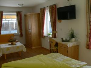 a bedroom with a bed and a desk and a tv at Gasthof Engel in Bad Wurzach