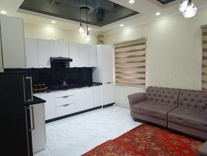 a living room with a couch and a kitchen at COMFORT house in Khiva