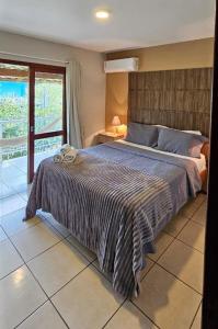 a bedroom with a large bed with a large window at Pousada Marina do Sol in Florianópolis