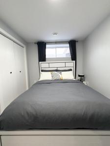 a bedroom with a large bed with a window at Spacious Entire Basement Suite with Free Parking Self Check In in Winnipeg