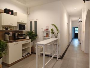 a kitchen with white cabinets and a counter with plants at Chino Town at Yaowarat Phuket - SHA Plus in Phuket