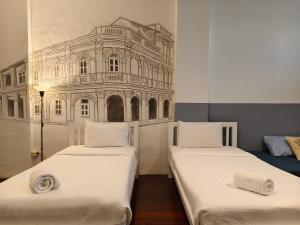 two beds in a room with a drawing on the wall at Chino Town at Yaowarat Phuket - SHA Plus in Phuket
