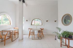 a dining room with tables and chairs and a window at RedDoorz near Exit Toll Tanah Baru Bogor in Bogor