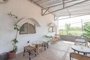 a room with tables and chairs and windows at RedDoorz near Exit Toll Tanah Baru Bogor in Bogor