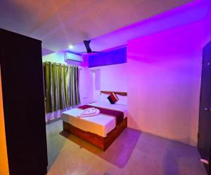 a bedroom with a bed with pink lights on it at Cascade View in Cochin