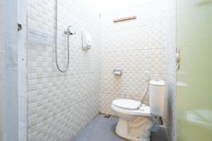 a bathroom with a toilet and a shower at RedDoorz near Exit Toll Tanah Baru Bogor in Bogor +19 photos