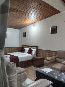 a hotel room with a bed and a couch and chairs at The Cup House in Namchi +3 photos