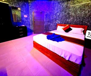 a bedroom with a bed with purple lights on it at Cascade View in Cochin +16 photos