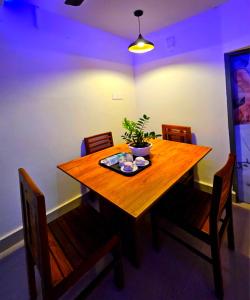 a wooden table with chairs and a potted plant on it at Cascade View in Cochin