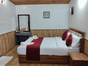 a bedroom with a large bed and a mirror at The Cup House in Namchi