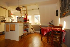 eine Küche mit einem Tisch und eine Küche mit einem Kühlschrank in der Unterkunft Saint-Malo Apartment in Saint-Malo