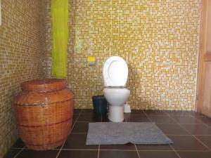 a bathroom with a toilet and a trash can at VILLA Paradisakely in Nosy Be