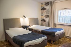 ein Hotelzimmer mit 2 Betten und einem Fenster in der Unterkunft Sjögestad Motell in Vikingstad