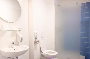 a bathroom with a white toilet and a sink at Sport Hotel Ljubljana in Ljubljana +32 photos
