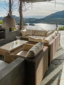 a group of wicker couches sitting on a patio at Cozy Cabin With Økstrafjord View in Jelsa