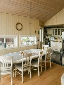 a kitchen with a large white table and chairs at Cozy Cabin With Økstrafjord View in Jelsa