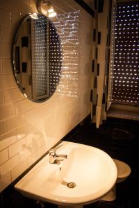 een badkamer met een wastafel en een spiegel bij Interno 10 in Siracusa