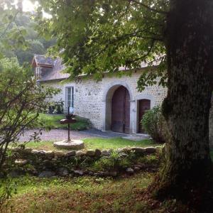 a stone house with a large door and a yard at Gite-Holiday Home Au Moulin 1771 in Monein +15 photos