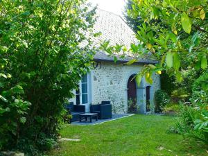 una casa de ladrillo blanco con un banco en el patio en Gite-Holiday Home Au Moulin 1771 en Monein