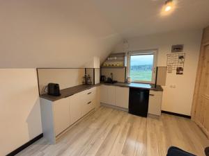 a large kitchen with white cabinets and a window at Anielski Apartament z prywatną balią in Szaflary