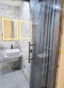a bathroom with a shower and a sink at Tazinn in Wayanad