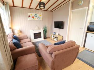 a living room with two couches and a fireplace at Moggs Retreat in Skegness