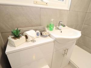 a bathroom with a white sink and a white toilet at Moggs Retreat in Skegness +23 photos