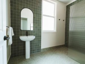 a bathroom with a sink and a mirror and a shower at Commercial Hotel Boonah in Boonah +16 photos