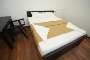 a bed in a room with a desk and a bed sidx sidx sidx at EK Residency in Anaviratty
