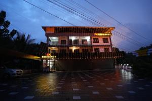 a building with christmas lights in a parking lot at EK Residency in Anaviratty
