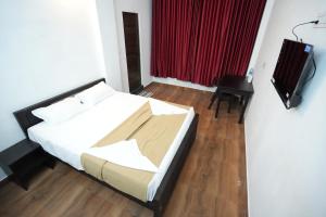 a bedroom with a bed and a television in it at EK Residency in Anaviratty