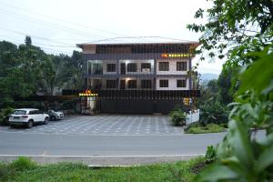 a building with a parking lot in front of it at EK Residency in Anaviratty