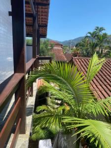 a balcony with a palm tree on a building at Dina Suítes Flat's Caiçara in São Sebastião