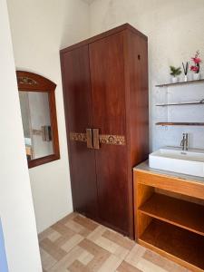 a bathroom with a sink and a wooden cabinet at Holi Saren Guest House in Nusa Dua