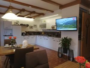 a kitchen with a table and a television on the wall at Haus Seppi in Neukirchen am Großvenediger
