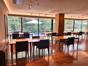 a restaurant with wooden tables and chairs and large windows at Sengokuhara Hisanoha in Hakone