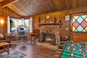 a living room with a fireplace and a pool table at 2583-Bernhardt Brown Bungalow in Big Bear City