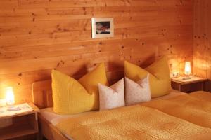 a bedroom with a bed with yellow pillows at Ferienbauernhof Liebschick in Egg