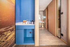 a bathroom with blue walls and a white sink at Atour Hotel Kunming Jiantou Building Jingkai District in Kunming +39 photos