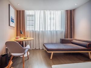 a room with a bed and a table and a window at Atour Hotel Kunming Jiantou Building Jingkai District in Kunming