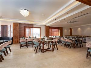 a restaurant with tables and chairs in a room at Faiz Resort Pahalgam in Pahalgām