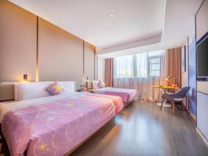 a hotel room with two beds and a television at Atour Hotel Kunming Jiantou Building Jingkai District in Kunming