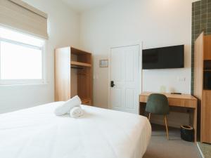 a bedroom with a bed and a desk and a television at Commercial Hotel Boonah in Boonah