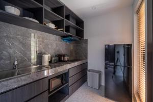 a kitchen with a sink and a refrigerator at Aranya Bliss Villa 101 in Ko Phangan