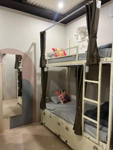 a room with two bunk beds and a mirror at Yovibe Stays, Dorms & Rooms, Assi Ghat, Varanasi in Varanasi