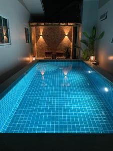 a swimming pool at night with a blue tile floor at Luxe Sands Pran in Ban Nong Ban Kao