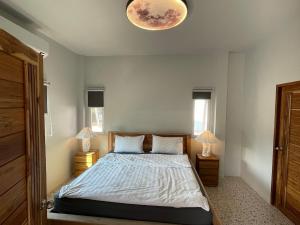 a bedroom with a bed with two lamps on two tables at Luxe Sands Pran in Ban Nong Ban Kao +18 photos